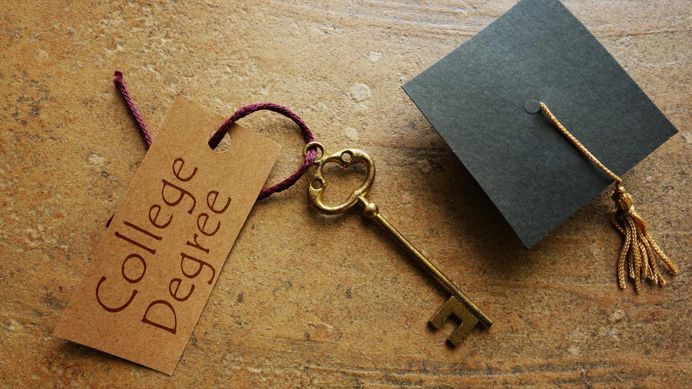 key with a tag that reads college degree next to a graduation cap and tassle