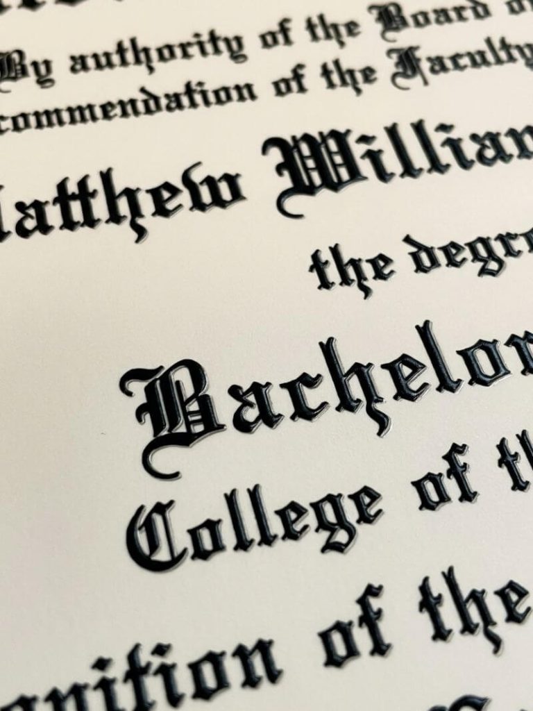 Close-up of raised black lettering on replica college diploma showing UV layered printing depth and dimension