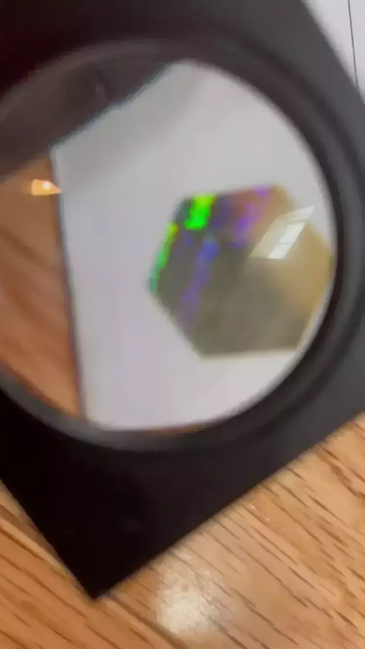 Magnifying glass zooms in on a self-destructive hologram security feature on a novelty academic transcript.